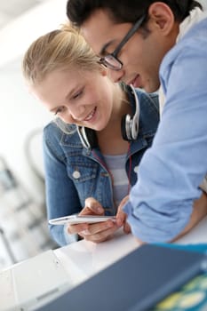 Young people in college lounge using smartphone