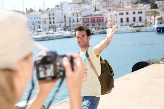 Woman taking picture of boyfriend on tourist journey