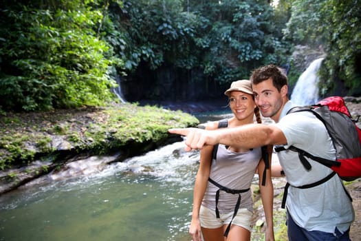 Trekkers reaching waterfall in natural landscape