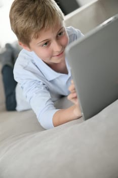 Portrait of pre-teen playing with tablet at home