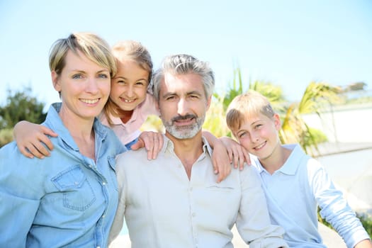 Happy family standing in home private garden