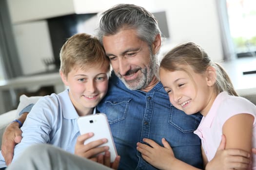 Man with kids playing with smartphone