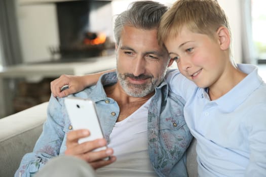 Daddy with son playing with smartphone