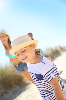 Little girl pulling parents' arms to run to the beach