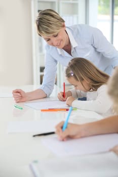 Teacher helping kids in classroom