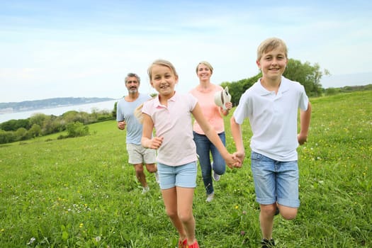 Family of four running in countryside