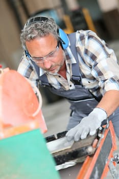 Tiler cutting tile with electric grinder