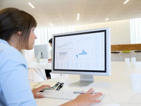 Back view of office worker in front of desktop