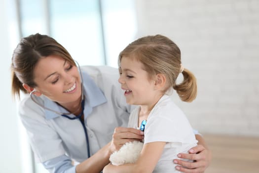 Doctor examining little girl with stethoscope
