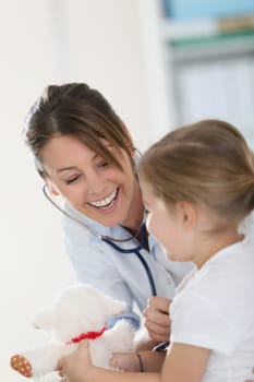 Doctor examining little girl with stethoscope
