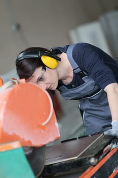 Young woman in professional training using tile grinder