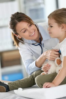 Doctor examining little girl with stethoscope