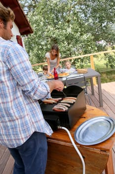 Closeup of man cooking grilled meat on barbecue