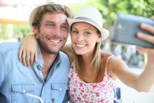 Couple of tourists taking selfie picture with smartphone