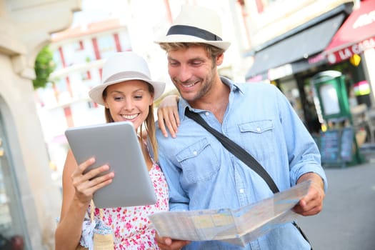 Couple in vacation looking at tourist guide on internet