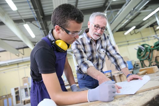 Carpenter with apprentice in training period