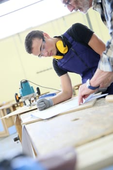 Carpenter with apprentice in training period