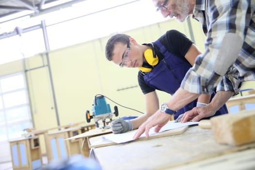 Carpenter with apprentice in training period