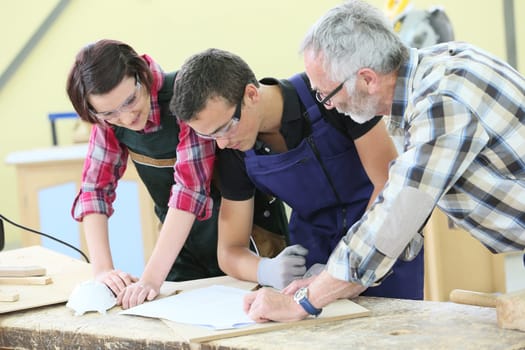 Young people in carpentry course with teacher