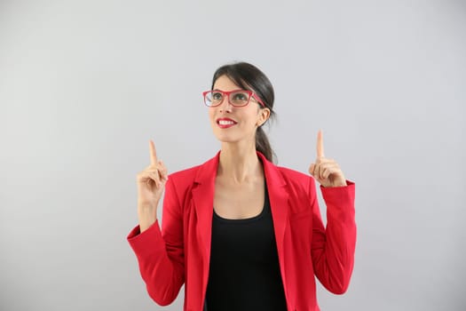Beautiful brunette girl with red jacket pointing at message