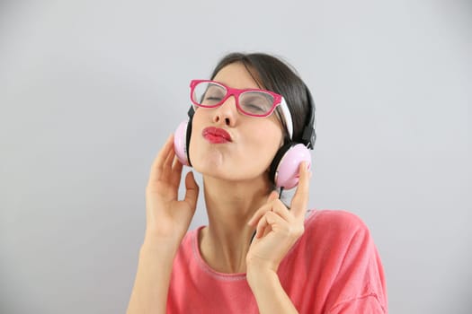Clsoeup of brunette girl with eyeglasses using headphones