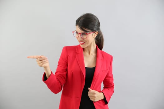 Beautiful brunette girl with red jacket pointing at message