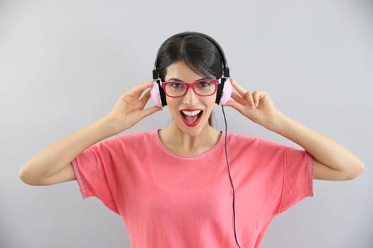 Clsoeup of brunette girl with eyeglasses using headphones