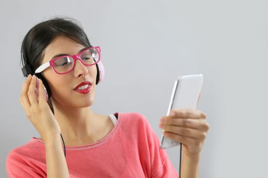 Brunette girl listening to music on smartphone, isolated