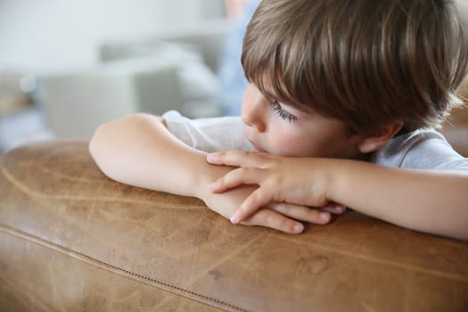 Portrait of cute little boy looking away, being sad