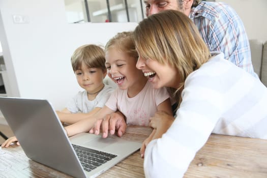 Parents with kids at home using laptop computer