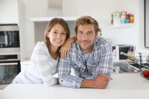 Portrait of couple standing in modern kitchen