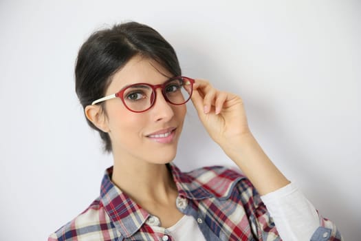 Portrait of brunette girl with red eyeglasses on, isolated