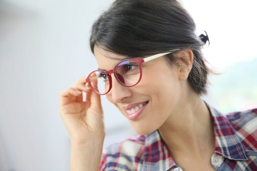 Portrait of brunette girl with red eyeglasses on, isolated