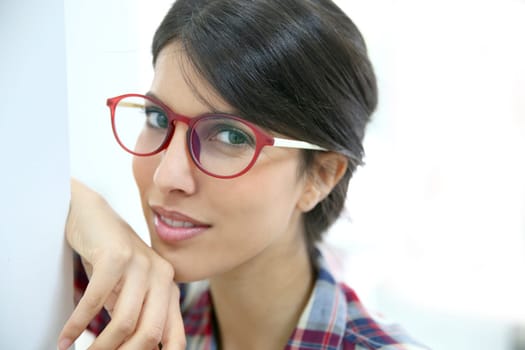 Portrait of brunette girl with red eyeglasses on, isolated