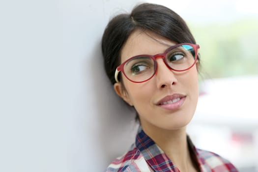 Portrait of brunette girl with red eyeglasses on, isolated