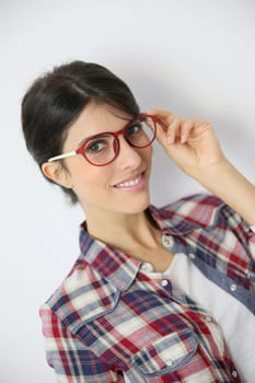 Portrait of brunette girl with red eyeglasses on, isolated