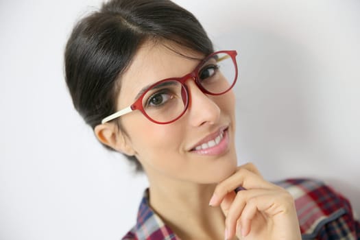 Portrait of brunette girl with red eyeglasses on, isolated