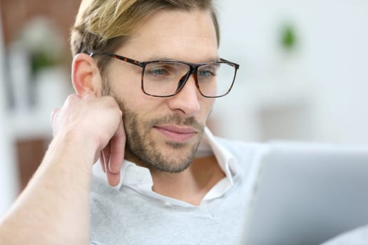 Man with eyeglasses connected on digital tablet at home