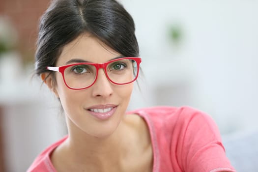 Portrait of beautiful brunette girl wearing red eyeglasses