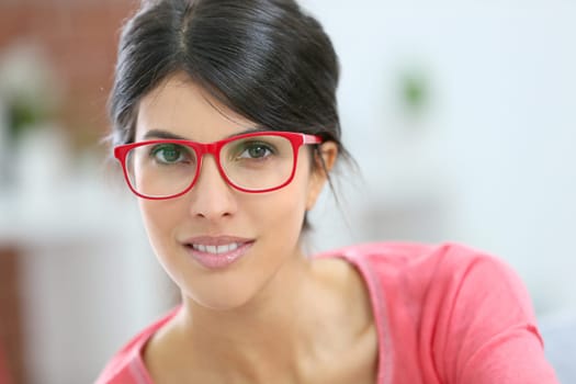 Portrait of beautiful brunette girl wearing red eyeglasses