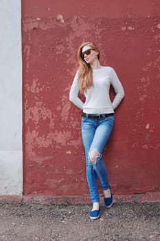 Portrait of a beautiful sexy blonde on the background of the old dilapidated wall