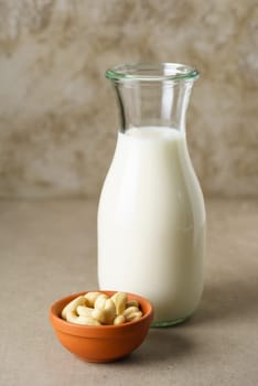Fresh homemade cashew milk in a bottle with fresh cashews