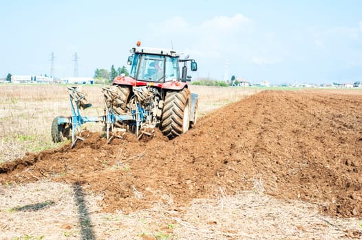 Agricultural work.  Tractor plowing the stubble field