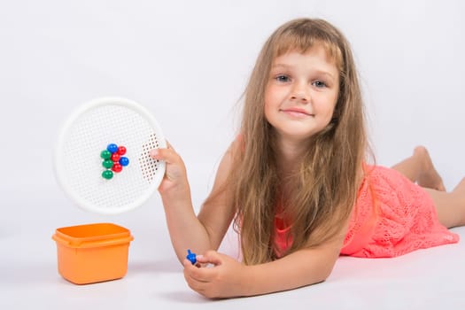 Girl shows a mosaic with unfinished flower