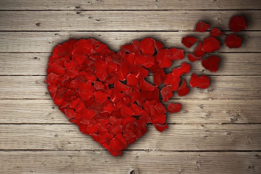 Red rose petals arranged in shape of a broken heart on wooden table. Broken heart breakup concept separation and divorce icon. Symbol of medical cardiovascular health