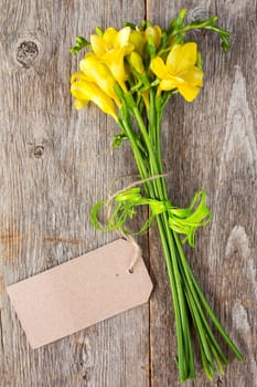 Bouquet of freesia flowers  with blank tag tied with string