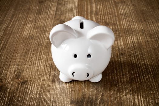 Piggy bank on the old wooden background, front view