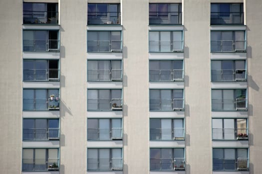 A multi-storey residential building with terraced windows and railings.