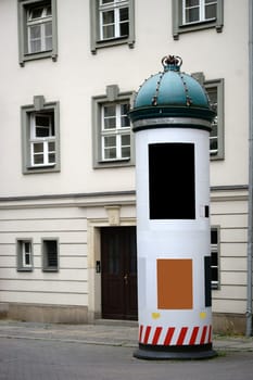 A column with posters and posters in the city center of Berlin and with a lace bent to the crown.