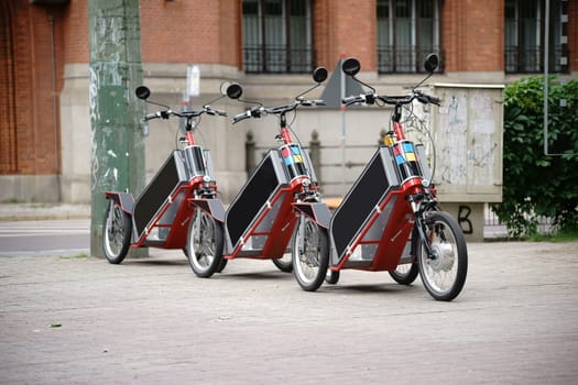 Bicycles or tricycles are lined up one after the other for rental.